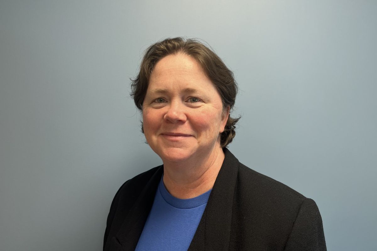 Constance Bedan, Assistant Dean for Finance and Administration, smiling, wearing a black blazer and blue shirt
